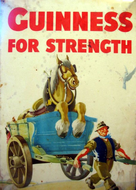 Guinness strength ad of  man pulling horse in wagon